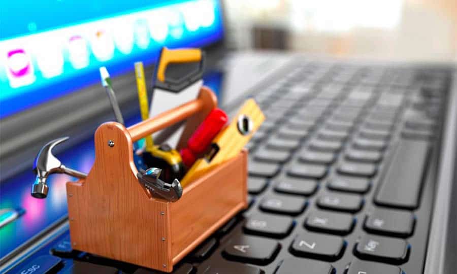 Uma caixa de ferramentas sobre um teclado de um laptop ilustrando as ferramentas de marketing para vendas
